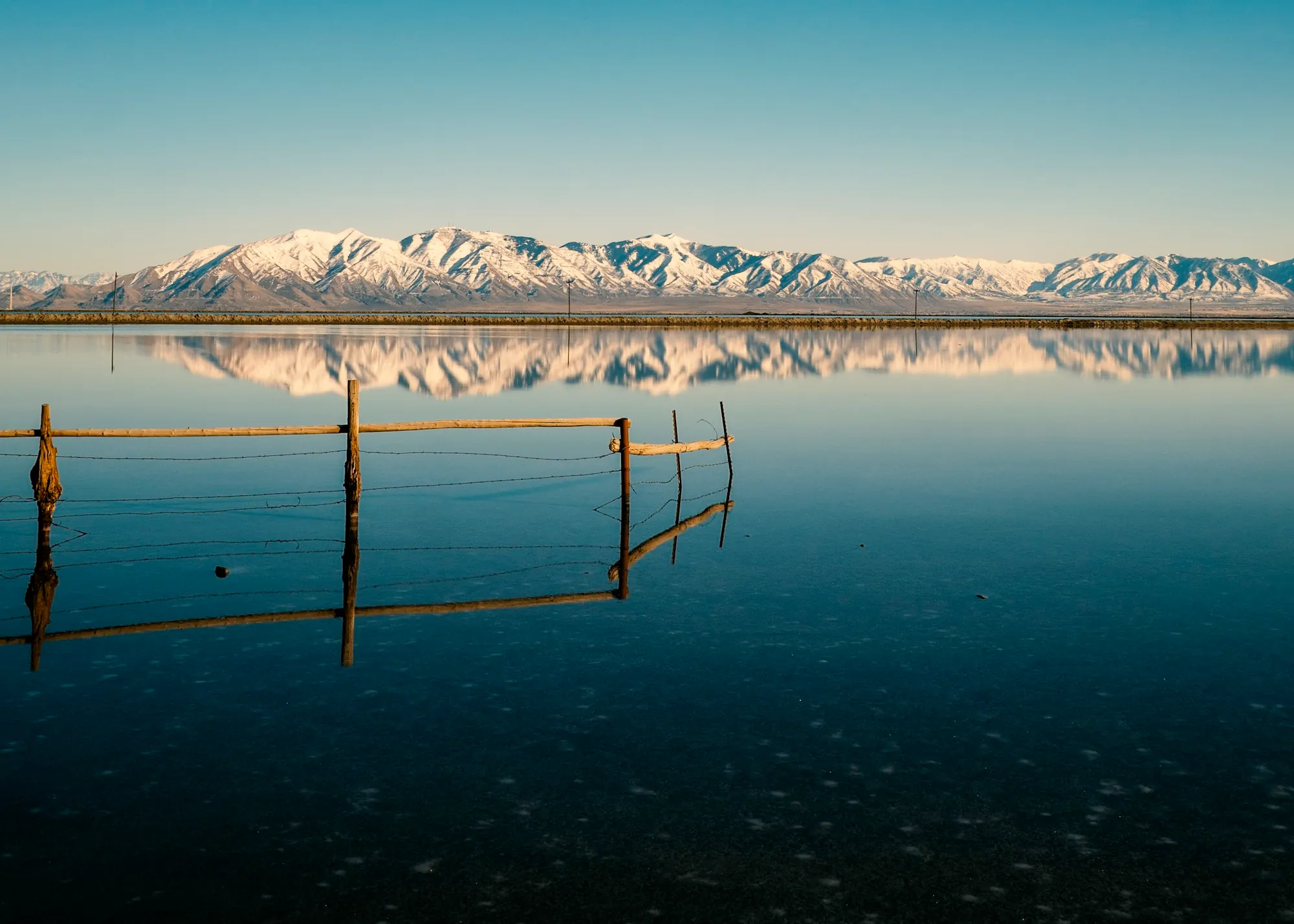 A snowy mountain above still water