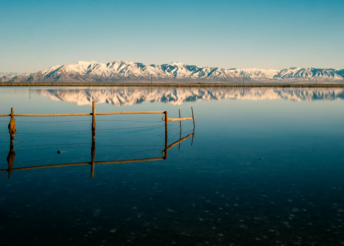 A snowy mountain above still water